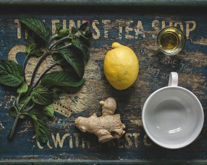 Wooden tray with mint, lemon, ginger root, honey and an empty teacup