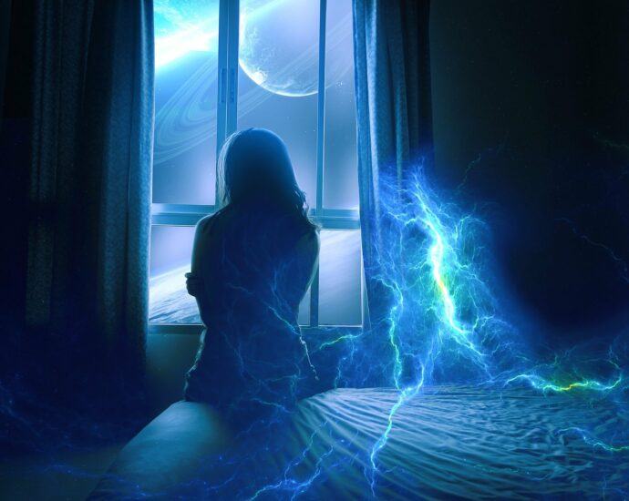 Illustration of a person sitting on the side of a bed surrounded by lightning in the room. They are looking out of the window at the planet jupiter.